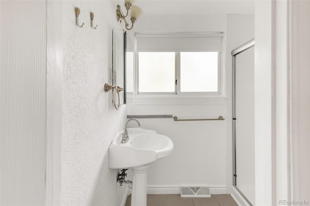 6535 Balsam St, Arvada, CO 80004 - full bathroom with a stall shower, tile patterned floors, and baseboards