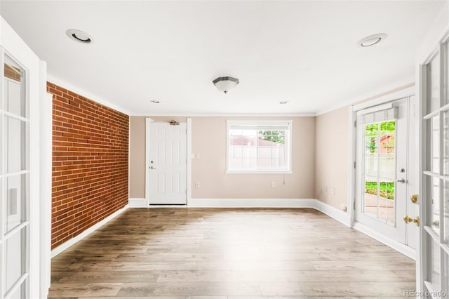 6535 Balsam St, Arvada, CO 80004 - foyer with wood finished floors, brick wall, baseboards, ornamental molding, and french doors