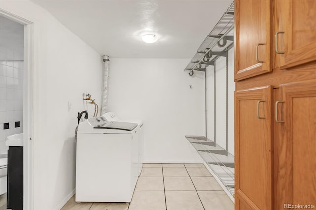 6535 Balsam St, Arvada, CO 80004 - laundry area with separate washer and dryer, light tile patterned floors, and baseboards