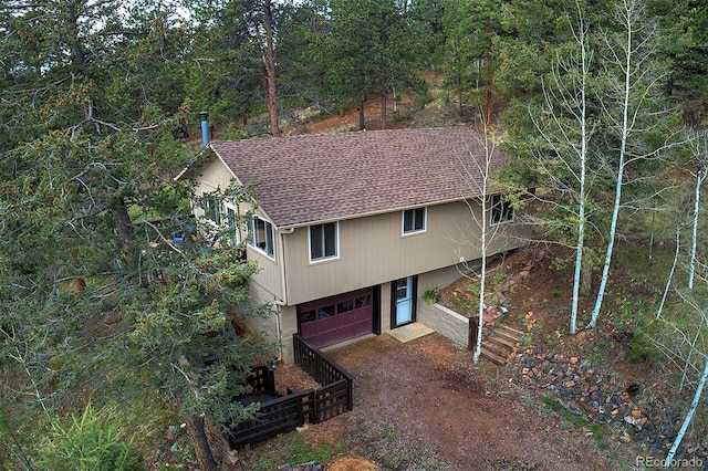 11669 S Upper Ranch Dr, Pine, CO 80470 - view of front of house featuring an attached garage, driveway, a shingled roof, and a wooded view