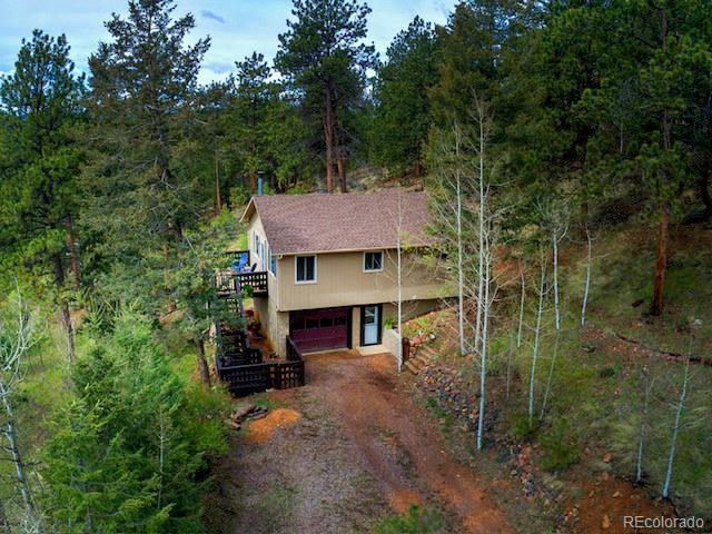 11669 S Upper Ranch Dr, Pine, CO 80470 - view of front of property featuring dirt driveway, a garage, a view of trees, and stairway