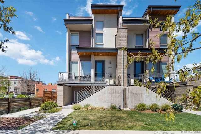 2409 Court Pl, Denver, CO 80205 - view of front of home featuring stairs, stucco siding, a front yard, and fence