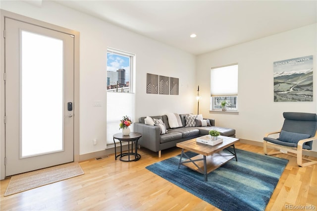 2409 Court Pl, Denver, CO 80205 - living room featuring visible vents, recessed lighting, light wood finished floors, and a healthy amount of sunlight