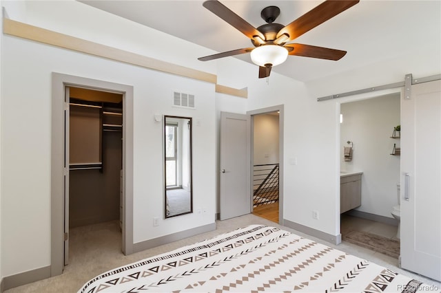 2409 Court Pl, Denver, CO 80205 - unfurnished bedroom with visible vents, a closet, a walk in closet, a barn door, and connected bathroom