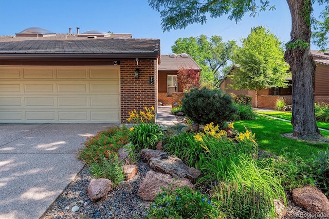 view of front of property featuring a front lawn, an attached garage, brick siding, and driveway