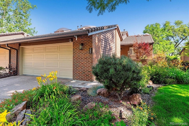 view of front facade with a garage, brick siding, and driveway