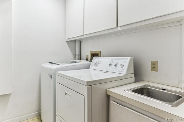 laundry room featuring baseboards, cabinet space, and washing machine and clothes dryer