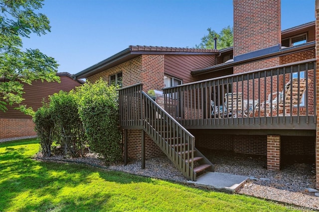 wooden deck with stairway and a lawn