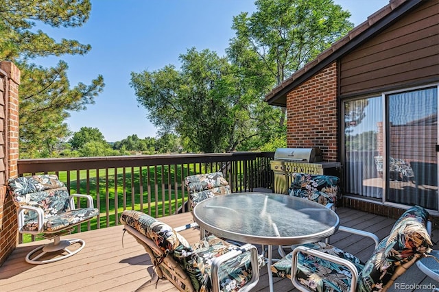 wooden terrace featuring outdoor dining space and area for grilling