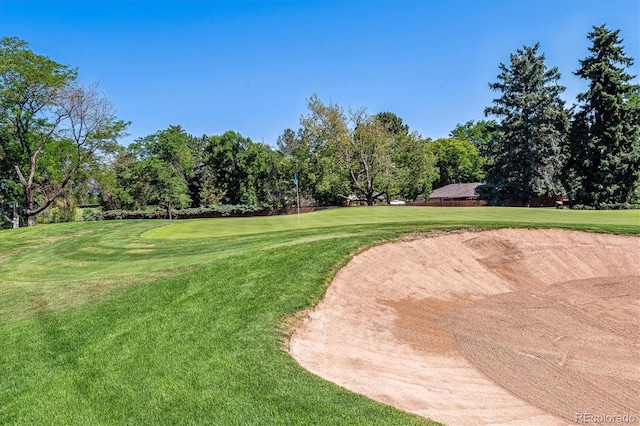 view of home's community with a lawn and view of golf course