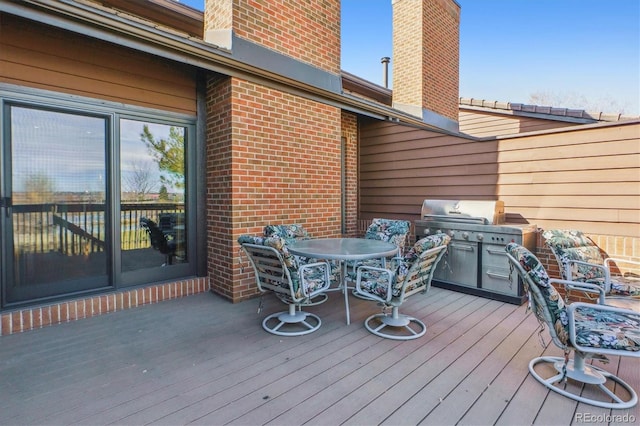 deck featuring a grill and outdoor dining space