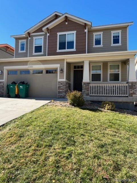 craftsman inspired home with a garage, a front yard, and covered porch