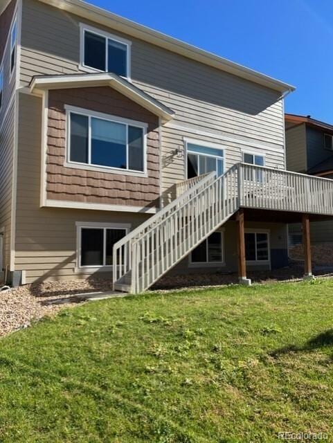 rear view of property with a yard and a deck