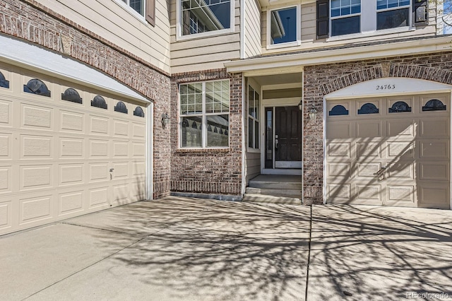 24763 E Crestridge Pl, Aurora, CO 80016 - view of exterior entry with an attached garage, driveway, and brick siding