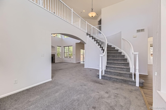 24763 E Crestridge Pl, Aurora, CO 80016 - interior space featuring arched walkways, baseboards, visible vents, and a towering ceiling