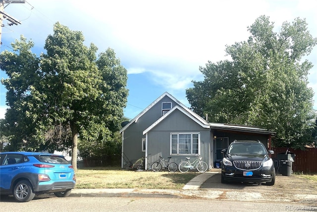 ranch-style house featuring fence, an attached carport, and a front yard