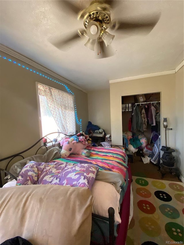 bedroom with a closet, a ceiling fan, and crown molding