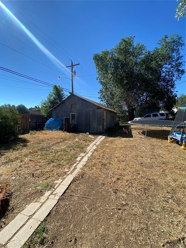 exterior space featuring fence and an outbuilding