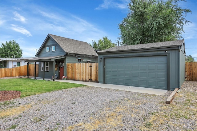 view of front of property with a garage, an outbuilding, and a front lawn