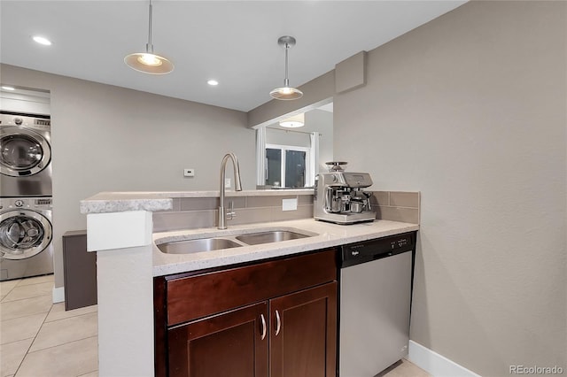 kitchen featuring sink, hanging light fixtures, stacked washer / drying machine, and dishwasher