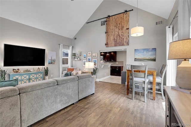 living room with light wood-type flooring and high vaulted ceiling