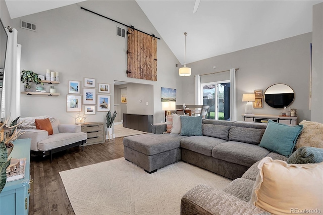 2310 S Decatur St, Denver, CO 80219 - living area featuring high vaulted ceiling, a barn door, and wood finished floors