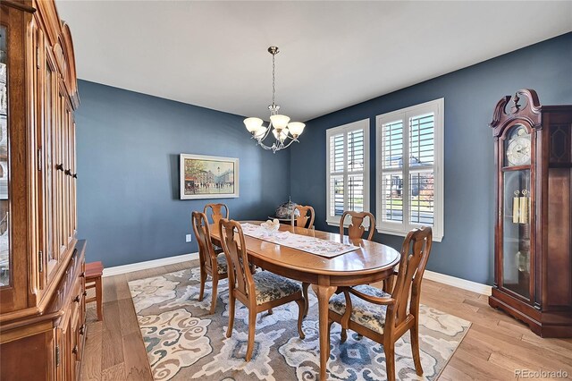 dining area featuring light hardwood / wood-style floors and a chandelier