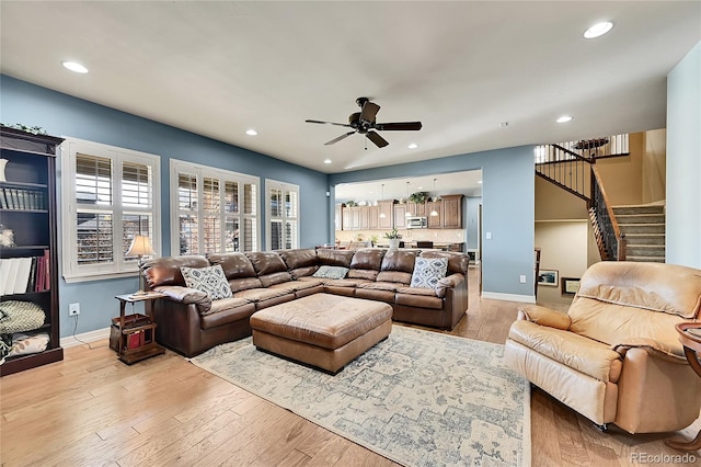 living room featuring ceiling fan and light hardwood / wood-style flooring