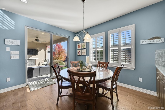 dining area featuring hardwood / wood-style floors and ceiling fan with notable chandelier