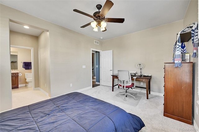 bedroom featuring ceiling fan, connected bathroom, and light carpet