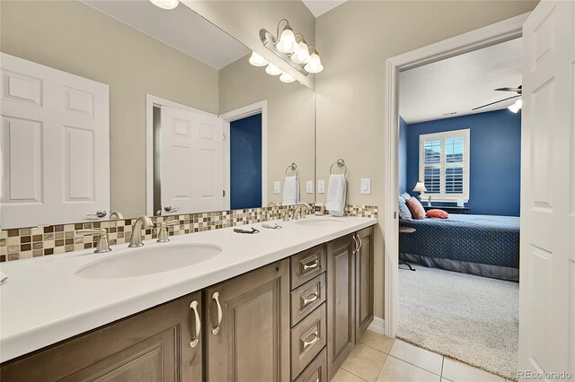 bathroom featuring vanity, ceiling fan, tile patterned flooring, and decorative backsplash