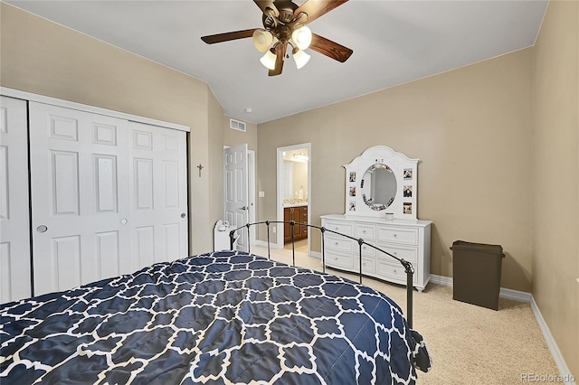 bedroom with a closet, light carpet, ceiling fan, and ensuite bath