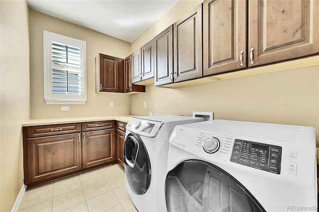 laundry area featuring cabinets, light tile patterned floors, and separate washer and dryer