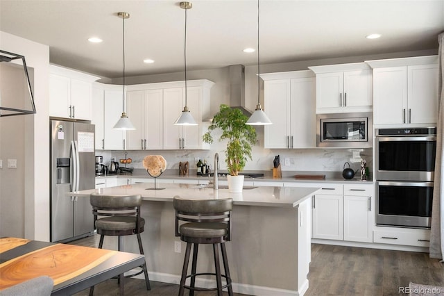 kitchen featuring a kitchen island with sink, appliances with stainless steel finishes, white cabinetry, and pendant lighting