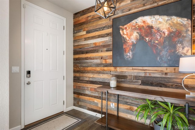 foyer entrance featuring wood walls and dark wood-type flooring