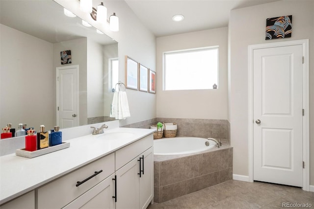 bathroom featuring vanity, tile patterned flooring, and tiled tub