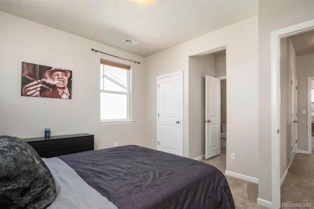 carpeted bedroom featuring ensuite bath