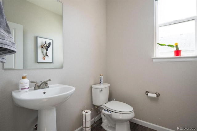 bathroom with toilet, sink, and hardwood / wood-style floors