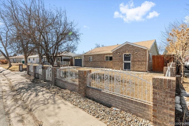 view of front facade featuring brick siding, a fenced front yard, a gate, and a residential view