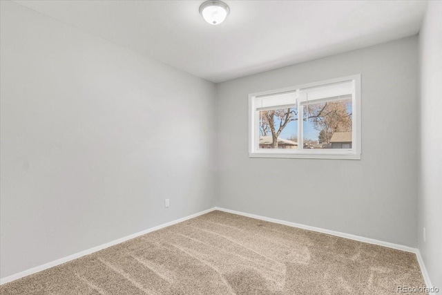 empty room featuring carpet floors and baseboards