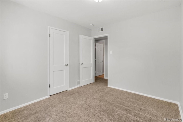 unfurnished bedroom with carpet floors, visible vents, and baseboards