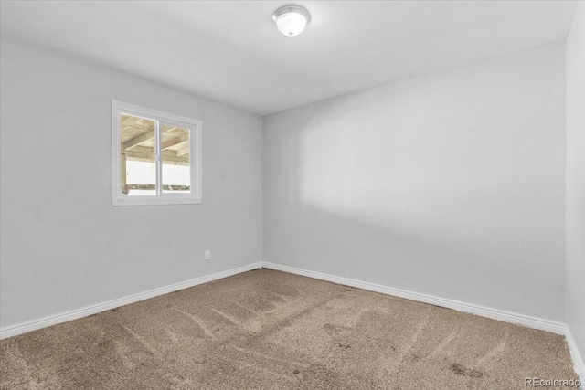 spare room featuring carpet and baseboards