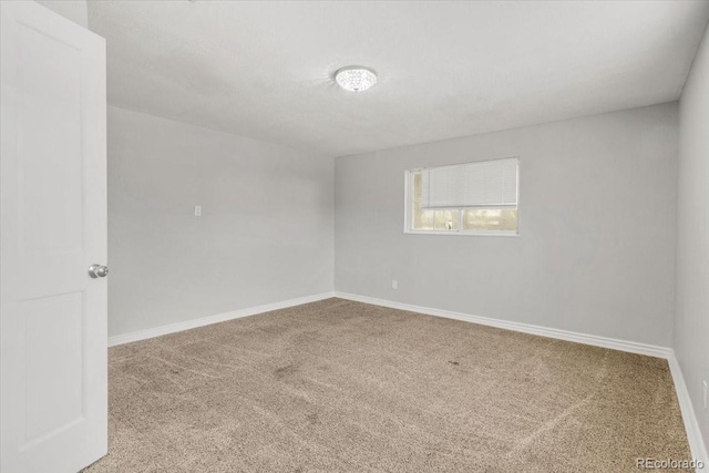 carpeted spare room with baseboards