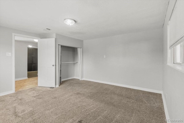 unfurnished bedroom with a closet, carpet flooring, and baseboards