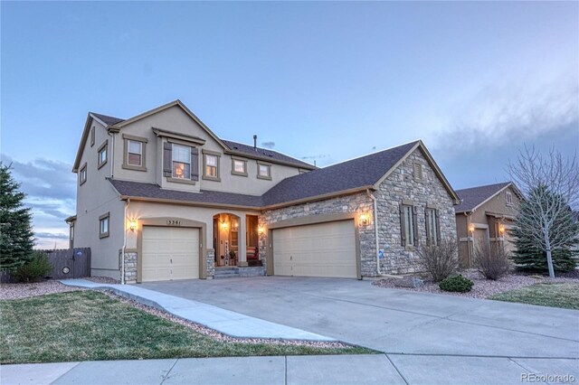 5361 Gem Lake Ct, Colorado Springs, CO 80924 - traditional-style home with concrete driveway, stone siding, an attached garage, fence, and stucco siding