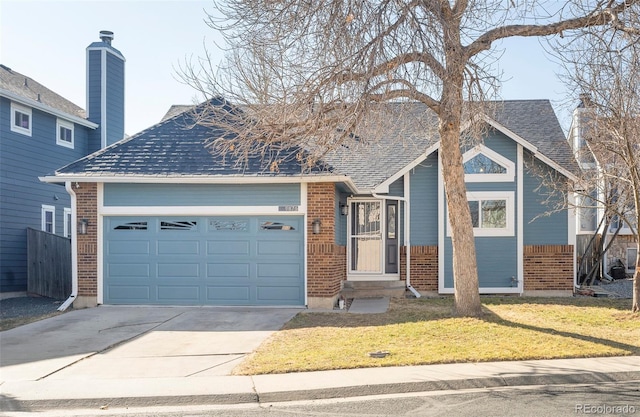 single story home with a front lawn, brick siding, an attached garage, and roof with shingles