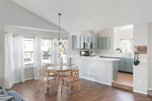 dining area with plenty of natural light, visible vents, vaulted ceiling, and dark wood-style flooring