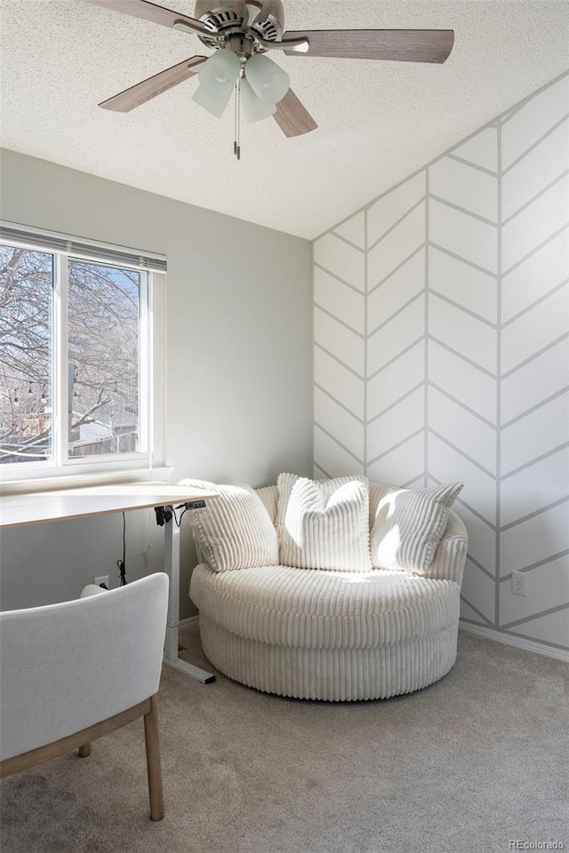 sitting room with a textured ceiling, ceiling fan, and carpet