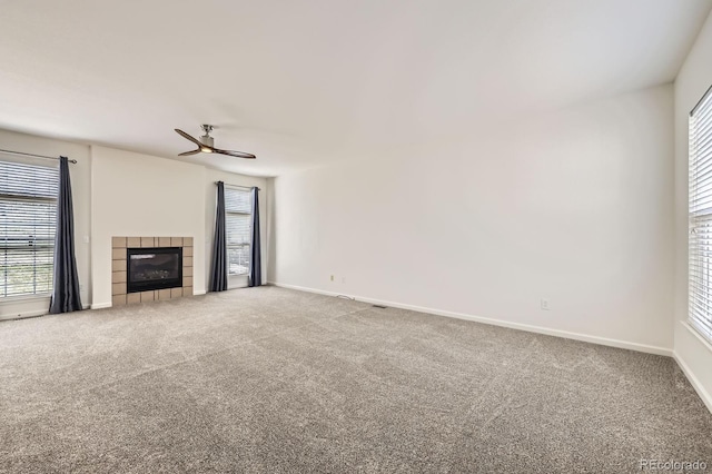 unfurnished living room with carpet, a fireplace, and plenty of natural light