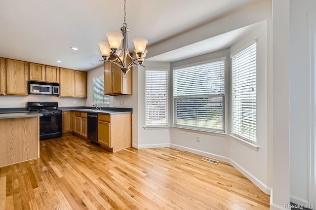 kitchen featuring gas stove, stainless steel microwave, dishwashing machine, light wood-style flooring, and plenty of natural light